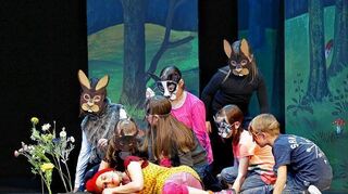 <p>Die Tiere des Waldes (Schüler der Hubäckerschule) nähern sich dem schlafenden Rotkäppchen (Melina Schoefer) - eine Szene aus dem Musical, das in der Stadthalle Uraufführung feierte.</p>