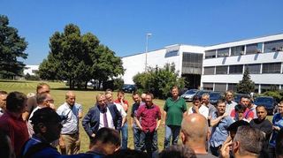 <p>Verhandlungen über den Sozialplan: Die Belegschaft wird während der Verhandlungsrunden unterrichtet von Klaas Uphoff, Per-sonalleiter Europa von Cooper Standard (im Anzug), Marc Berghaus, IG Metall (braunes Poloshirt) und Walter Keller, Betriebs-ratsvorsitzender (rotes Hemd, linker Bildteil). Rechts unten: Rohre, die für den Versand vorbereitet sind.</p>