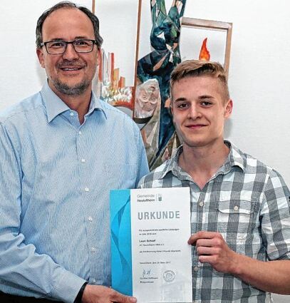 <p>Bürgermeister Gunther Hoffmann überreicht einem stolzen Leon Schaaf die Urkunde für ausgezeichnete sportliche Leistungen im Jahr 2016.</p>