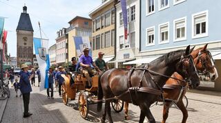 <p>Mit Kutsche, Gefolge und großen Fahnen ziehen die Kirrweiler durch die Stadt, um ihren - inzwischen freiwilligen - Zehntel am Dom abzuliefern.</p>