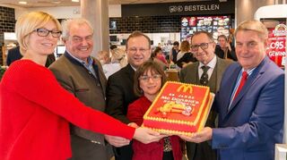 Eine Torte mit Ronald McDonald zu Jubiläum und Wiedereröffnung: Dehoga-Ge-schäftsführerin Melanie von Görtz (v. l.), Dehoga-Landesvize Waldemar Schretz, Bürgermeister Thomas Jakob-Lichtenberg, IHK-Sprecherin Petra Hörmann, Alt-OB Gustav Schrank und Manfred Büch unterstützen das Backwerk.