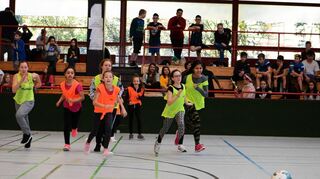 Zu Beginn des Turniers tritt die Klasse 5 (orangefarbene Leibchen) gegen die Klasse 6 in Gelb an. Beim Kampf um das runde Leder schenken sich die Feldspieler nichts.