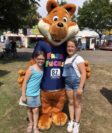 Die beiden Freundinnen Elisabeth (l.) und Paula lassen sich mit Fred Fuchs, dem lebensgroßen Maskottchen der Bruhrainer Zeitung, ablichten.
