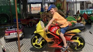 Der drei Jahre alte Matz aus Oberhausen fährt im Karussell auf einem Motorrad.