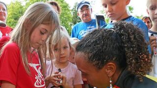 Geduldig schreibt die Europameisterin Autogramme auf TSV-Shirts.