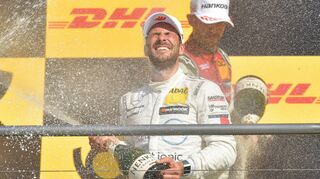 Gary Paffett (vorne) genießt die Sektdusche von René Rast. Der Audi-Pilot hatte den Kampf um die DTM-Krone mit zwei Laufsiegen Schluss spannend gemacht.