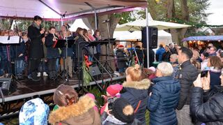 Statt Schnee gibt es Regen, aber die Brühler kommen trotzdem zu ihrem Weihnachtsmarkt am Wochenende vor dem Heiligen Abend und genießen auch ein fröhliches Bühnenprogramm – hier mit den Sängern und Instrumentalisten der Jahnschule.
