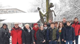 Die triste Szenerie im verschneiten Auschwitz passt zur bedrückenden Stimmung an dieser Gedenkstätte. Hoffnung spendet die Skulptur am Eingang, vor der die Schüler mit ihren Lehrern stehen.