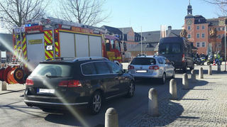 Auf der Kreuzung vor dem Schloss postiert sich die Feuerwehr, um den Verkehr daran zu hindern, in die Karlsruher Straße einzufahren.