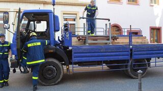 Vom Lkw werden die Stützbalken und Eisenpfeiler abgeladen, die das THW zur Absicherung des Hauses braucht.