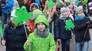 Die Kinder der Humboldschule haben an ihre Stecken Frösche angeklebt. Voller Freude auf die verbrennung des Schneemanns ziehen sie durch die Straßen.