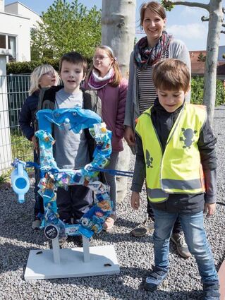 Lehrerin Anne Johann mit Kindern der Comenius-Schule vor ihrer Skulptur aus gesammeltem Abfall.