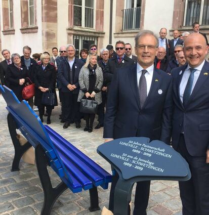 Jacques Lamblin und Dr. René Pöltl mit den Jubiläumsgeschenken. Auf einem Gingkoblatt-Aufsteller ist die Freundschaft festgehalten.
