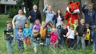 Eins, zwei, drei – und los! Kinder der Eulen- und Froschgruppe der Melanchthon-Kita werfen mit Kita-Leiterin Bianca Ehlert (hinten v. l.), David Kniebühler, Susanne Geiß, Lea Götzmann, Pfarrer Steffen Groß und natürlich dem Kindernachrichtenmaskottchen Fred Fuchs Blühbälle.