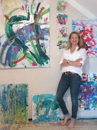 Sabine Wendtland zeigt einige ihrer Werke. Das große Bild neben der Künstlerin hat den Titel „Le printemps“.