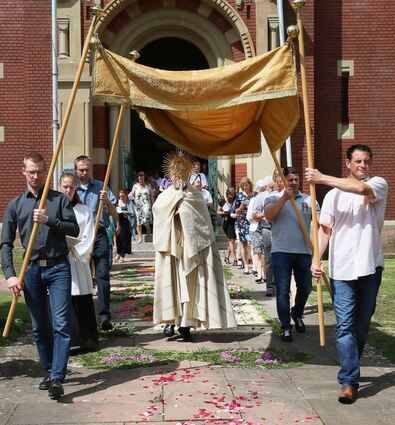Feierliche Prozession an der Sankt-Nikolaus-Kirche: Pfarrer Reinholdt Lovasz schreitet mit der Monstranz voraus.