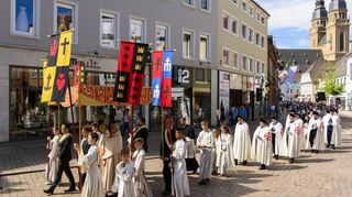 Auf dem Prozessionsweg: Unterm Baldachin trägt Bischof Dr. Karl-Heinz Wiesemann die geweihte Hostie in einer goldenen Mon-stranz von der Kirche St. Joseph (r.) über Gilgenstraße, Postplatz und Maximilianstraße zur Abschlussfeier im Dom.