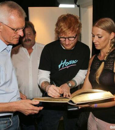 Ed Sheeran (Mitte) trug sich vor seinem zweiten Konzert auf dem Hockenheim-ring in Anwesenheit von OB Dieter Gummer (v. l.), Ring-Geschäftsführer Georg Seiler und Sabrina Schleyer (Stadtverwaltung) ins Goldene Buch der Stadt ein.