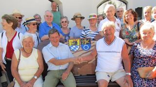 Empfang in Schrobenhausen: Bürgermeister Karlheinz Stephan (l.) reicht Hermann Wörn vom Obst- und Gartenbauverein die Hand auf der Motivbank, die die Stadt Schwetzingen den Freunden aus Oberbayern geschenkt hatte.