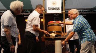 Noch einen Schlag – Bürgermeister Jürgen Kappenstein sticht unter den Augen von Festzeltwirt Armin Reichelt (r.) und Binding-Repräsentant Johannes Noky sowie Trélazes Bürgermeister Marc Goua (l.) das Bierfass an.