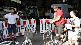 Sergei Terentjew (v. l.), Bauhofleiter Jürgen Ballweg und Rathausmitarbeiterin Sandra Garmann mit einem Teil der zu versteigern-den Fahrräder.