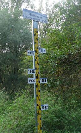 Eine beschriftete Pegelskala zeigt historische Hochwasser an.