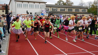 Der Start: Ein Teil der Athleten beginnt mit dem Laufen, so auch die späteren Sieger Team "Wein doch!" (vorne l., in Gelb). Andere Teilnehmer leeren erst die ersten Flaschen, bevor sie loslaufen.
