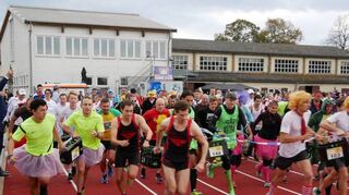 Der Start: Ein Teil der Athleten beginnt mit dem Laufen, so auch die späteren Sieger Team „Wein doch!“ (vorn l., in Gelb). Andere leeren bereits die ersten Flaschen.