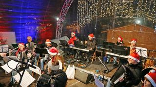 Das Hohner-Akkordeon-Orchester sorgt mit Instrumenten und roten Mützen auf der Bühne für ordentlich Stimmung.