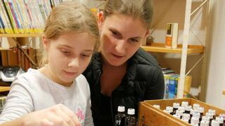Lena (8) und Mama Julia Weidenbruch bemalen in der Gemeindebücherei ein Seidentuch.