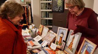 Brigitte Leskau (r.) zeigt Ulrike Auffahrt ihre Bilder mit Plankstadt-Motiven, die sie beim Kunsthandwerkermarkt zum Verkauf anbietet.