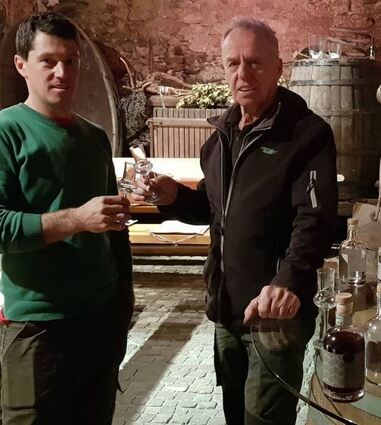 Matthias Gögele stößt mit Vater Hans im schönen Weinkeller des „Torgglerhofes“ mit eigenen Brände an.