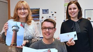 Bürgermeisterin Patricia Rebmann (v. l.), Marc Wiedmaier und Leonie Geffers freuen sich über die neue Infomappe für Neubürger, die auch auf USB-Stick erhältlich ist.