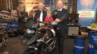 Früh übt sich, wer eine Bikerin werden will: Bei Andrés Kfz-Service nimmt Laura auf einer BMW Platz, während Peter (l.) und André Kühne aufpassen, dass nichts passiert.