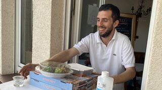 Aus dem Fenster reicht Enzo Panunzio von „Dolce e Salato“ die bestellten Speisen – der Abstand wird eingehalten.