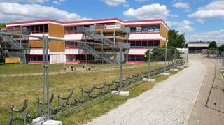 Die Neurottschule bleibt für mehrere Jahre eine Baustelle: Neben dem Neubau der Mensa (hinten rechts) und der Einrichtung von Lernbüros für den Ganztagsbetrieb wird der Brandschutz im Schulgebäude erneuert. Am Ende soll auch der Außenbereich komplett umgestaltet werden.