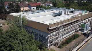 Die Rheinfrankenhalle ist von Baugerüsten umgeben: Das Dach bietet viel freie Fläche, die für eine Photovoltaikanlage genutzt wird.