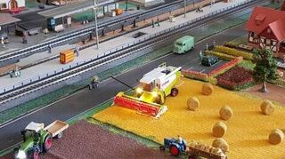 Ernteszene: Der Mähdrescher und der Traktor haben sogar Beleuchtung.