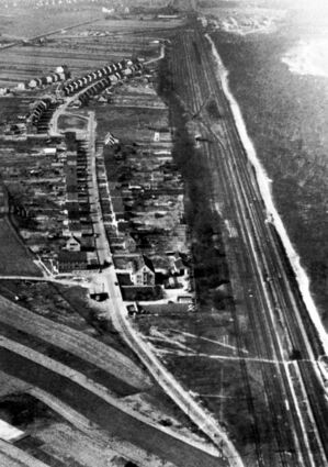 Der Hirschacker auf einem Luftbild aus dem Jahr 1957. Gut zu erkennen ist die im Vordergrund beginnende Rheintalstraße, die auf dem Marktplatz zuläuft. Von der geht am oberen Bildrand die Siedlerstraße weiter. Rechts ist die Bahnstrecke mit den Rangiergleisen zu erkennen.
