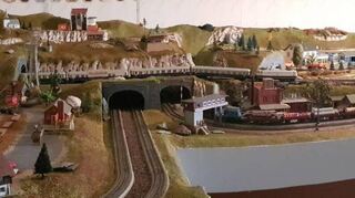 Auf etwa acht Quadratmetern fahren die Modellbahnen über die Gleise durch eine schöne Landschaft, die der Modellbahn-Fan in seinen Hobbykeller gebaut hat.