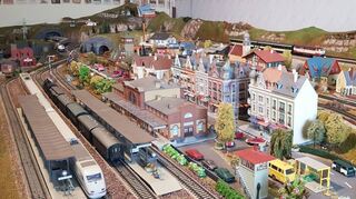 Im Bahnhof stehen zwei Züge und warten auf die Abfahrt, während der Feuerwehr-einsatz in der Straße vor dem Bahnhofsgebäude noch läuft.