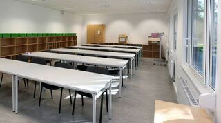 Eines der Klassenzimmer in der Hartmann-Baumann-Schule, das schon so gut wie fertig ist. Die Farbe grün spiegelt sich auch in den Behältern wieder, die für die Schüler bereitstehen.