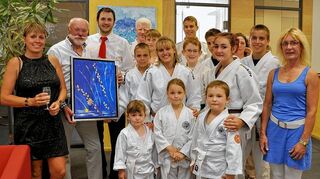 <p>Über die Ausstellungseröffnung in der Sparkasse freuen sich Judo-Vorsitzende Karin Mollet, Künstler Heinz Mollet und Sparkassen-Leiter Philipp Renninger (von links) sowie die Judo-Jugend und der Vorstand der Abteilung.</p>