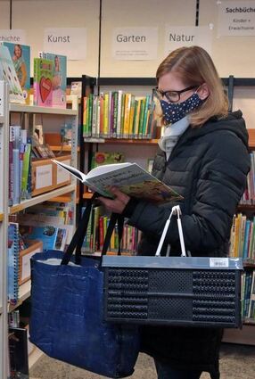 Antje Menzel stöbert in der Bücherei Neulußheim – natürlich mit Maske.
