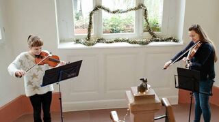 Das Violinen-Duo unter der Leitung von Marie Denise Heinen spielt im Treppenaufgang des Reilinger Rathauses.