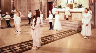 In weißer Kleidung stehen die Mädchen und Jungen in der katholischen Kirche in Hockenheim: Der Kinderchor und der Kinderchor des Madrigalchors singen unter der Leitung von Martina Rothbauer.