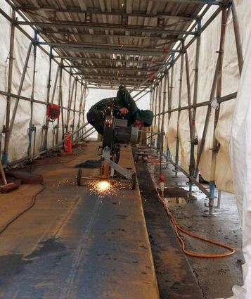 Vor dem Schweißen muss die Oberfläche der Stahlbrücke sauber abgeschliffen werden.