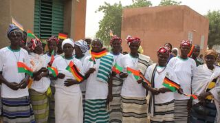 Bei einem früheren Besuch einer deutschen Delegation im westafrikanischen Burkina Faso zeigt sich diese Frauengruppe über die Partnerschaft von Brühl und Dourtenga begeistert. Sie schwenken die beiden Landesfahnen.