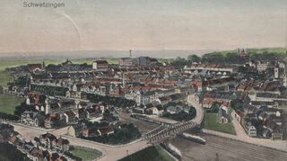 Diese 1918 entstandene Zeichnung zeigt eine Luftaufnahme von Osten mit Blick auf die Bahnlinie und die Stadt. Unten ist zu erkennen, wie die Strecke nach Heidelberg abbiegt.