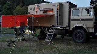Abendliches Campingleben vor dem Weltreisemobil, das durchaus Aufmerksamkeit erregt.